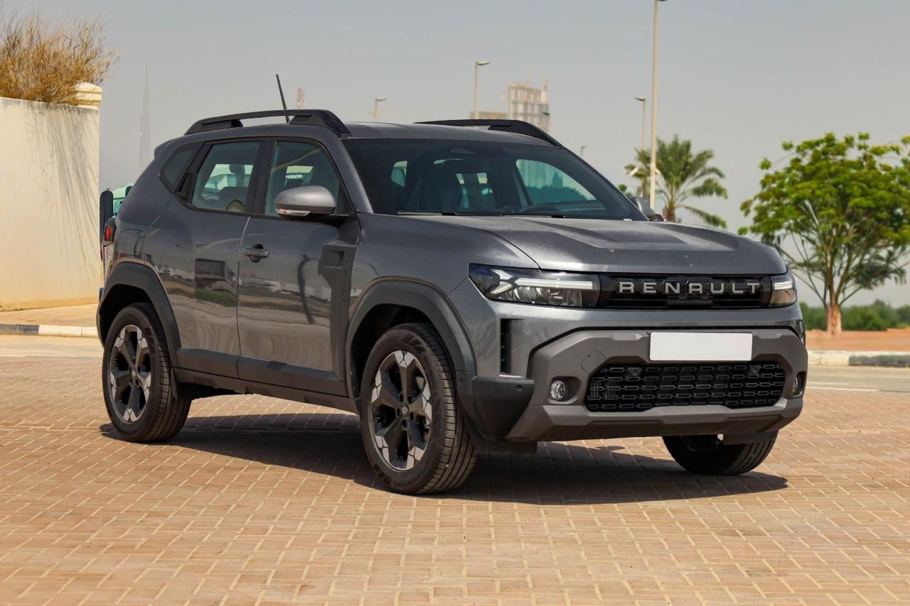 Seryy Renault Duster 3 pokoleniya, vid speredi-sboku, pustoy belyy platsderzhatel nomera